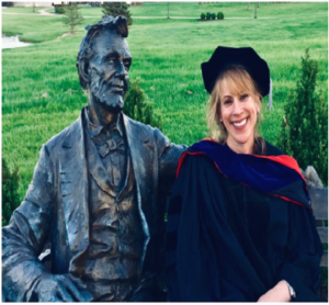 Photograph of Dr. Gregg with a statue of Abraham Lincoln